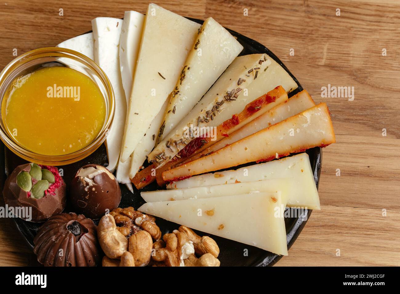 Ziegenkäse, Nüsse und Honig auf einem Teller und Kaffee daneben Stockfoto