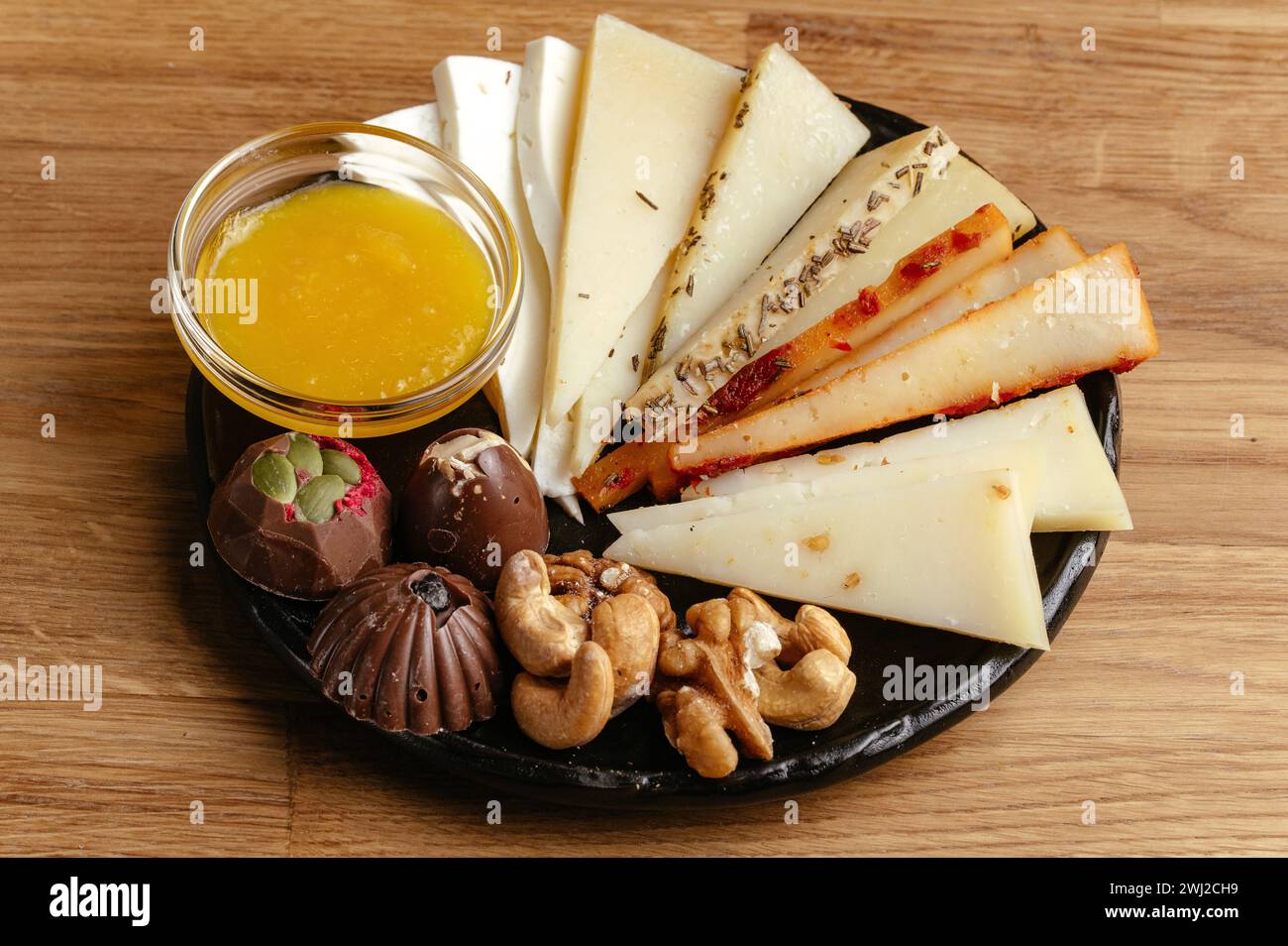 Ziegenkäse, Nüsse und Honig auf einem Teller und Kaffee daneben Stockfoto