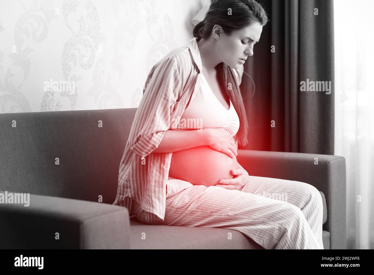 Schwanger Frau zu Hause. Verschiedene gesundheitliche Probleme während der Schwangerschaft. Stockfoto