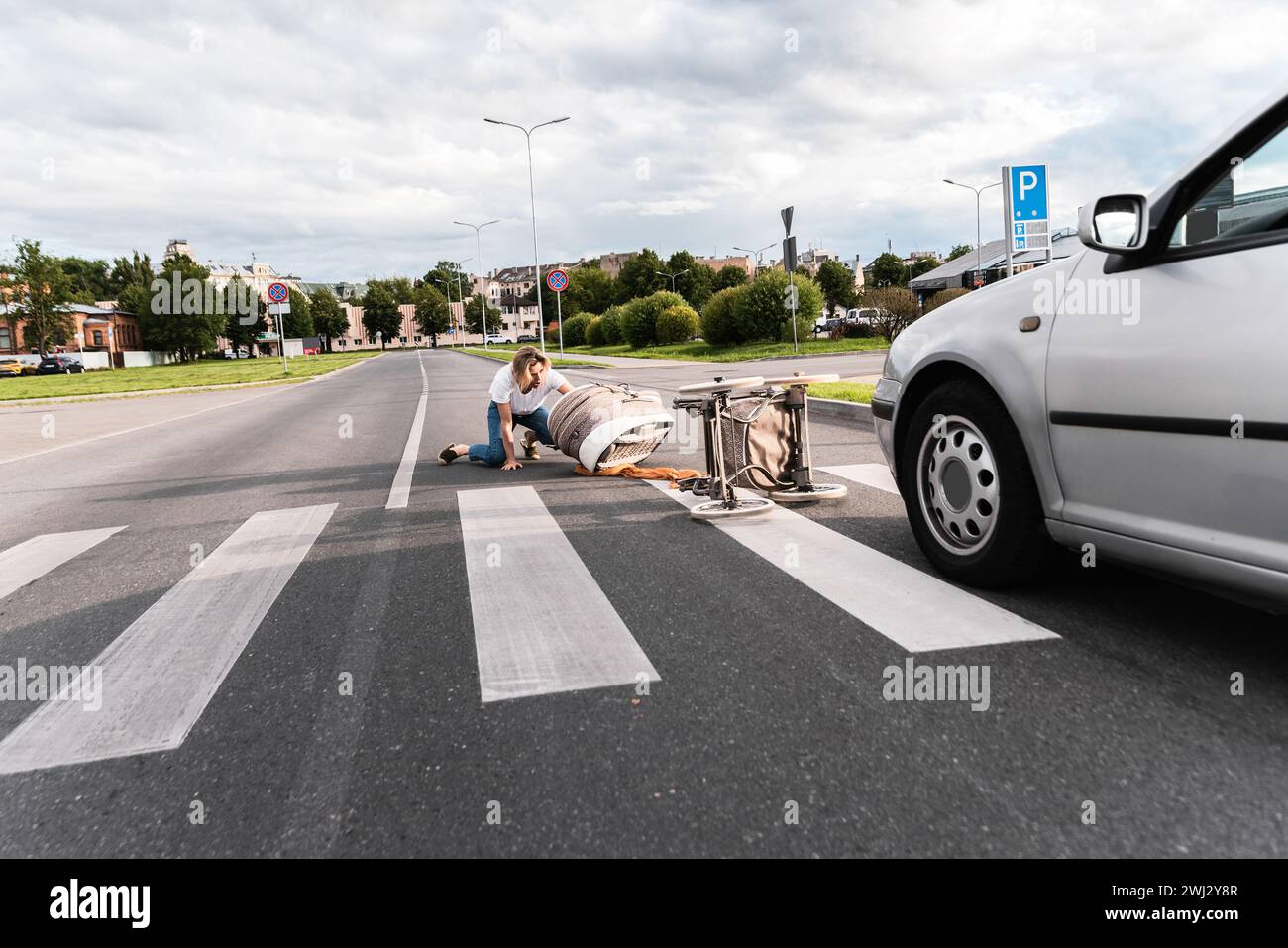 Schockierte Mutter auf dem Gehweg nach einem Autounfall, als das Fahrzeug ihren Kinderwagen traf Stockfoto