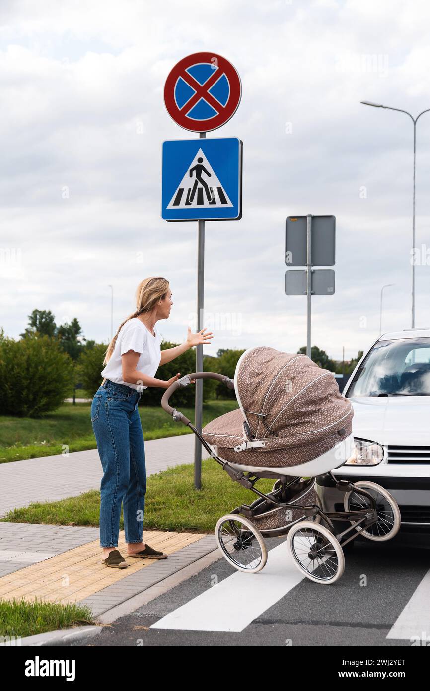 Mutter auf dem Gehweg nach einem Autounfall, als ein Fahrzeug ihren Kinderwagen trifft. Stockfoto
