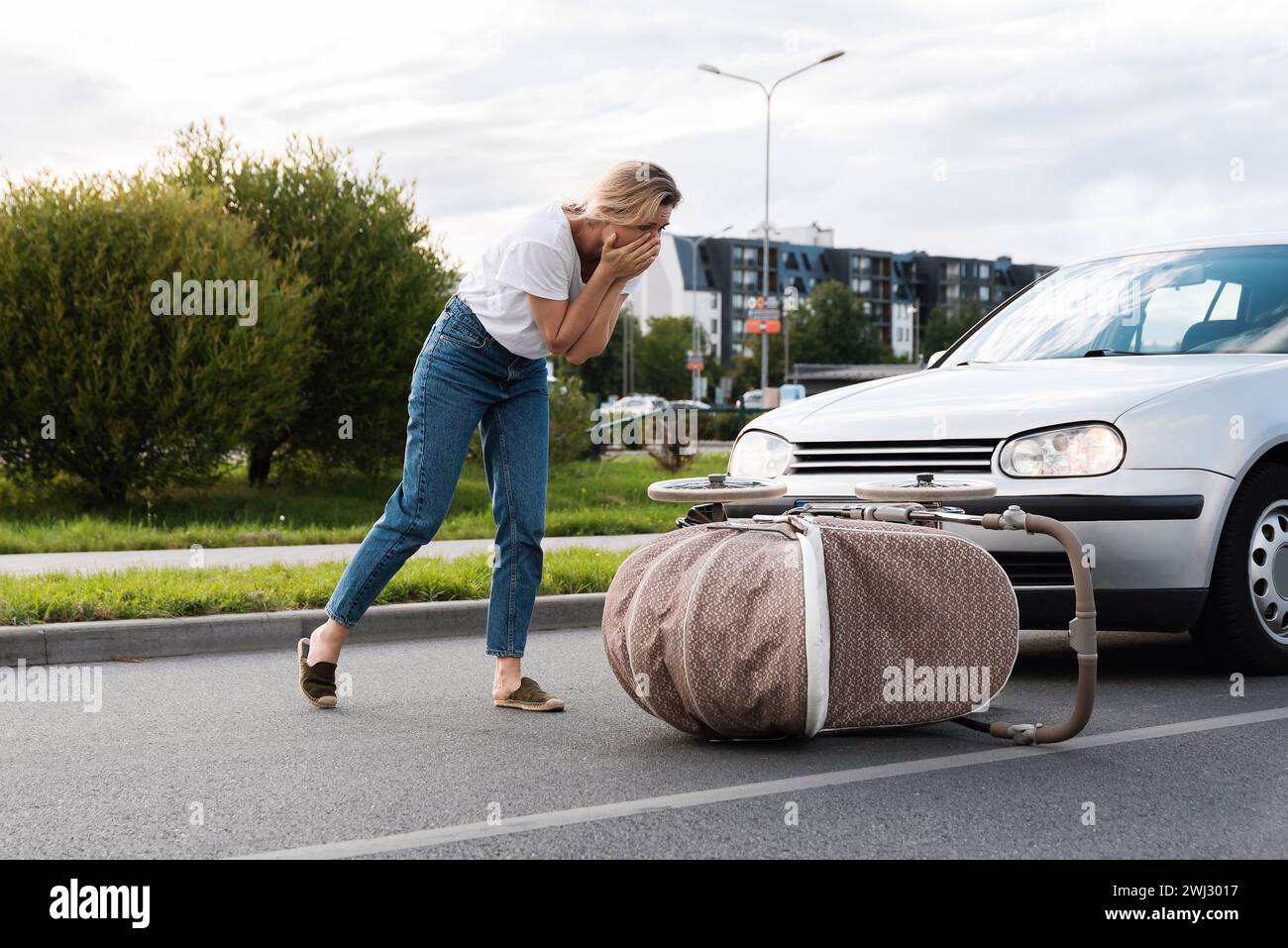 Entsetzte Mutter nach einem Autounfall, als ein Fahrzeug ihren Kinderwagen wegen des Wagengehens trifft Stockfoto