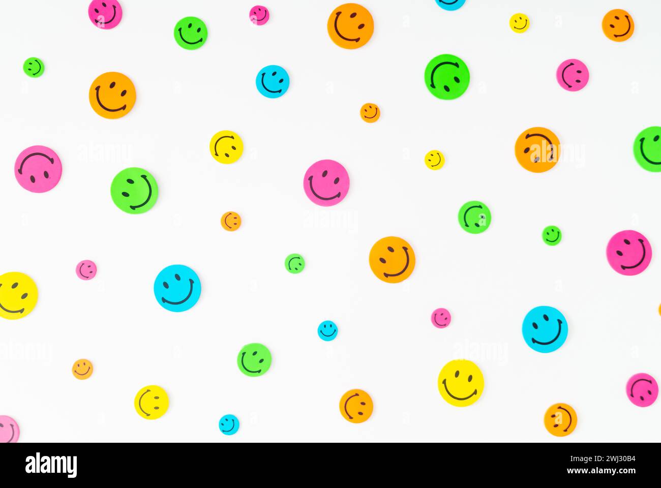 Farbenfrohe Musterkomposition mit Smiley-Aufklebern auf weißem Hintergrund. Minimales positives Denken und gute Stimmung. Stockfoto