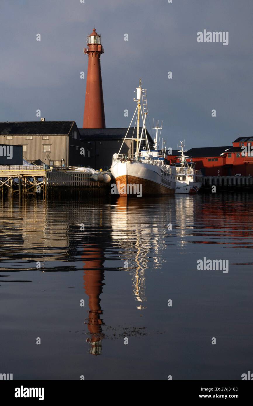 02.04.2023, Andoy, Nordland, NOR - Blick auf den Hafen mit dem Leuchtturm Andenes fyr. Andenes fyr, Andoy, aussen, Aussenaufnahme, Boote, Europa, europaeisch, Gebaeude, Gewaesser, Hafen, Hafenanlage, HF, Hochformat, Jahreszeit, Kueste, Kuestenlandschaft, Landschaft, Landschaftsaufnahme, Leuchtfeuer, Leuchtturm, Navigation, Navigationshilfe, niemand, Nordeuropa, Nordland, Norwegen, Norwegisch, Orientierungsfeuer, Richtfeuer, Schiffe, See, Seefeuer, Seezeichen, Signalanlage, Stadt, Wasser, Winter 230402D252ANDOY.JPG *** 02 04 2023, Andoy, Nordland, NOR Blick auf den Hafen mit dem Leuchtturm Ande Stockfoto