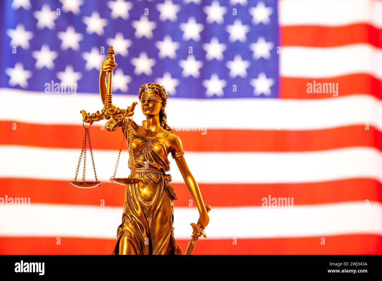 Statue der Gerechtigkeit. Nahaufnahme von Justice Lady Against Flag of America. America Justice - Konzept Stockfoto