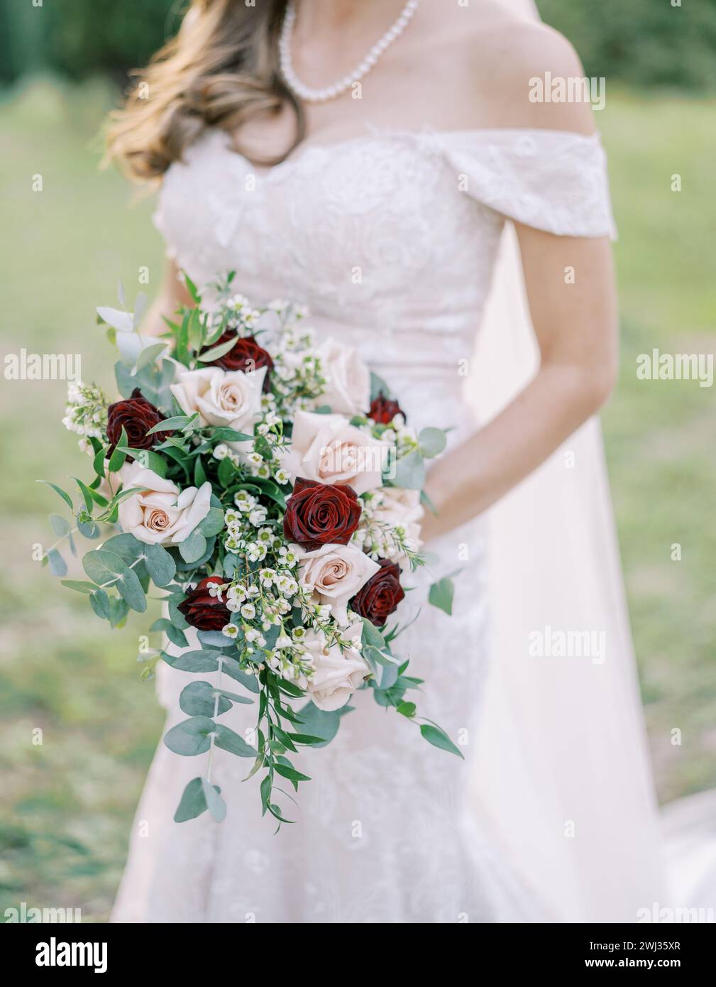 Braut mit einem Blumenstrauß in der Hand spaziert durch den Park. Abgeschnitten. Gesichtslos Stockfoto