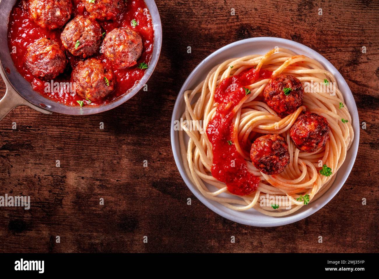 Fleischbällchen. Rindfleischbällchen, oben in einer Pfanne geschossen und mit einem Teller Spaghetti Stockfoto