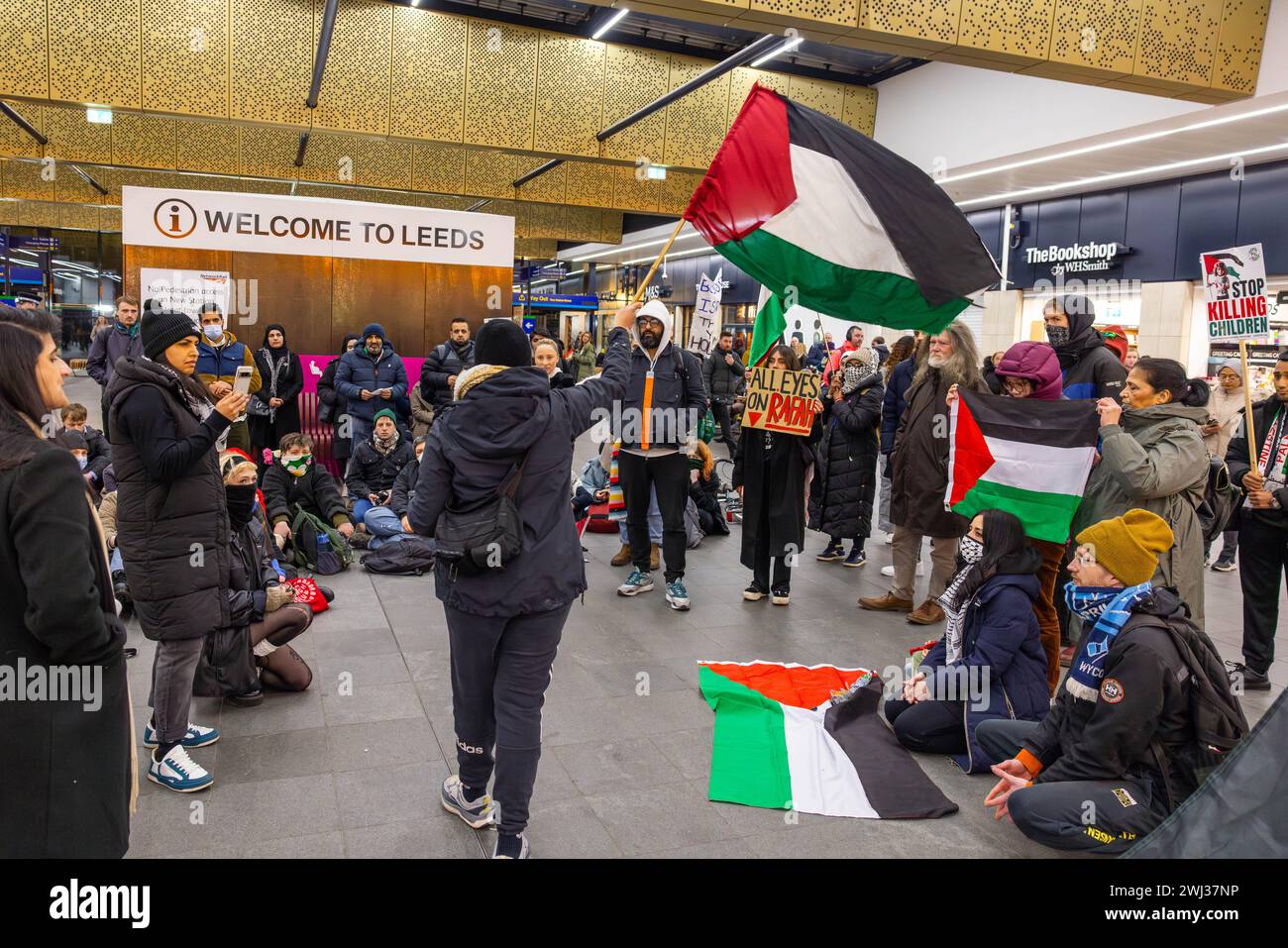 Leeds, Großbritannien. FEBRUAR 2024. Pro-palästinensische Demonstranten schwingen palästinensische Flagge vor anderen Demonstranten in der Hauptdurchfahrt zum Bahnhof Leeds. Credit Milo Chandler/Alamy Live News Stockfoto