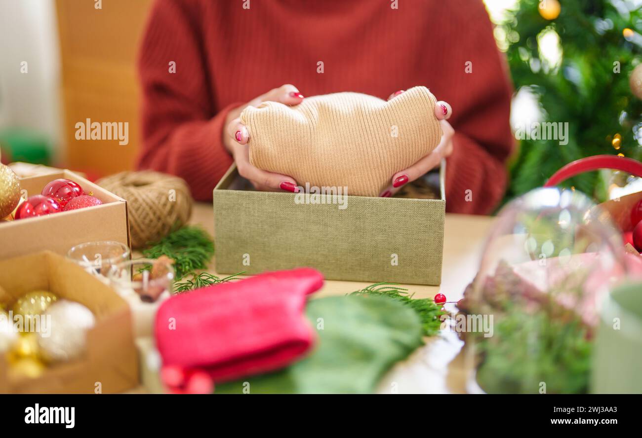 Frau im gestrickten Pullover Verpackung weihnachten presentsÂ mit Öko Papier Mädchen Verpackung weihnachtsgeschenke weihnachtsfeiertag Konzept Stockfoto