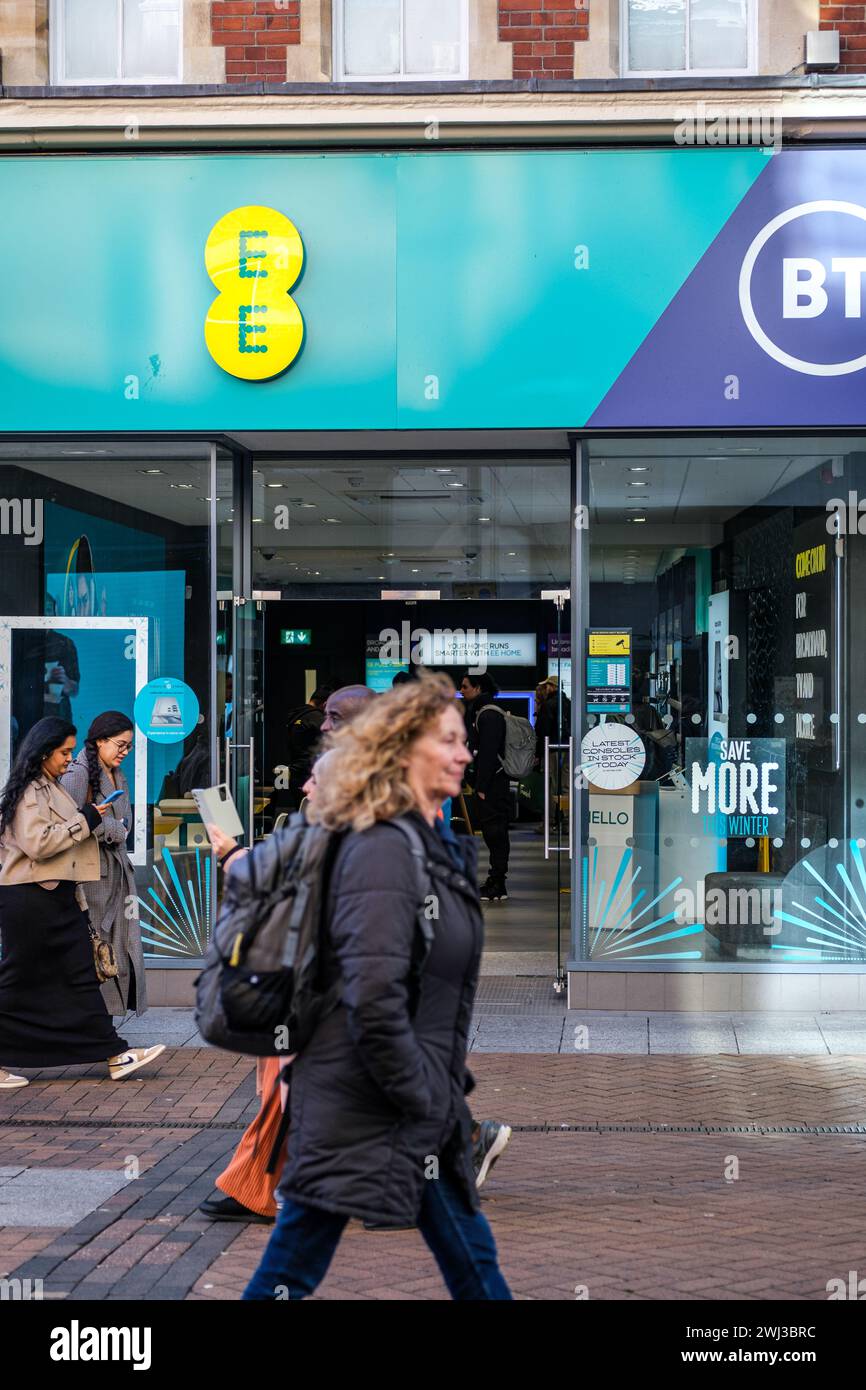 Kingston-upon-Thames, London, UK, 12. Februar 2024, Personen, die in einem High Street BT EE Mobile Phone Shop oder Store vorbeifahren und sich dort befinden Stockfoto