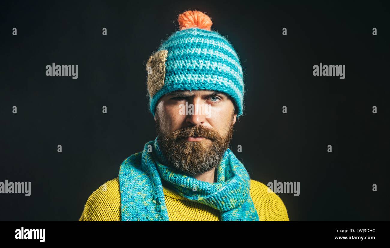 Porträt eines ernsthaften bärtigen Mannes in gelbem Pullover, blauem Schal und Hut. Herbst-Winter-Mode. Lässiger Look. Modischer Mann in Winterkleidung. Gut Aussehend Stockfoto