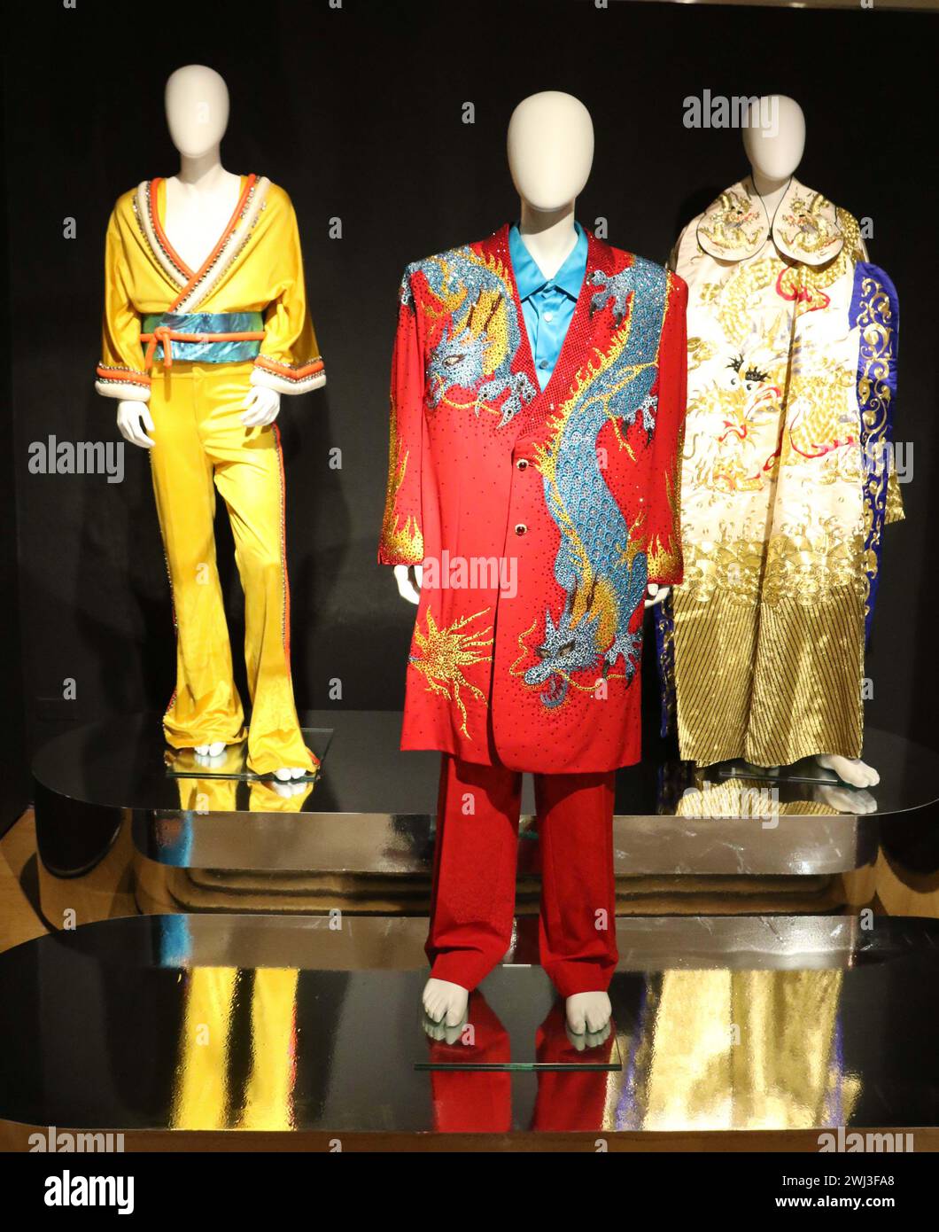 New York, New York, USA. Februar 2024. (L) Senfgelber Polyester-Kimono-inspirierter Jumpsuit und Jacke, wahrscheinlich Bob Mackie, ca. 1975, geschätzte $ 4.000 - $ 6.000, (C) Ein ''˜Chinese Dragon'-Anzug entworfen von Keith Gregory Fleming - Haberstroh, $ 3.000 - $ 5.000, und (L) Chinesisch bestickte Creme Seidenmantel $ 1.000 - $ 1.500, gesehen bei ''˜The Collection of Sir Elton John: auf Wiedersehen Peachtree Road im Christie's Rockefeller Center. Gegenstände stammen aus Eltons ehemaligem Haus in Atlanta. (Kreditbild: © Nancy Kaszerman/ZUMA Press Wire) NUR REDAKTIONELLE VERWENDUNG! Nicht für kommerzielle ZWECKE! Stockfoto