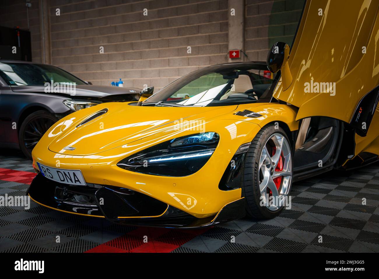 Der gelbe McLaren 765LT mit offenen Türen befindet sich in einer Hochleistungsgarage. Stockfoto