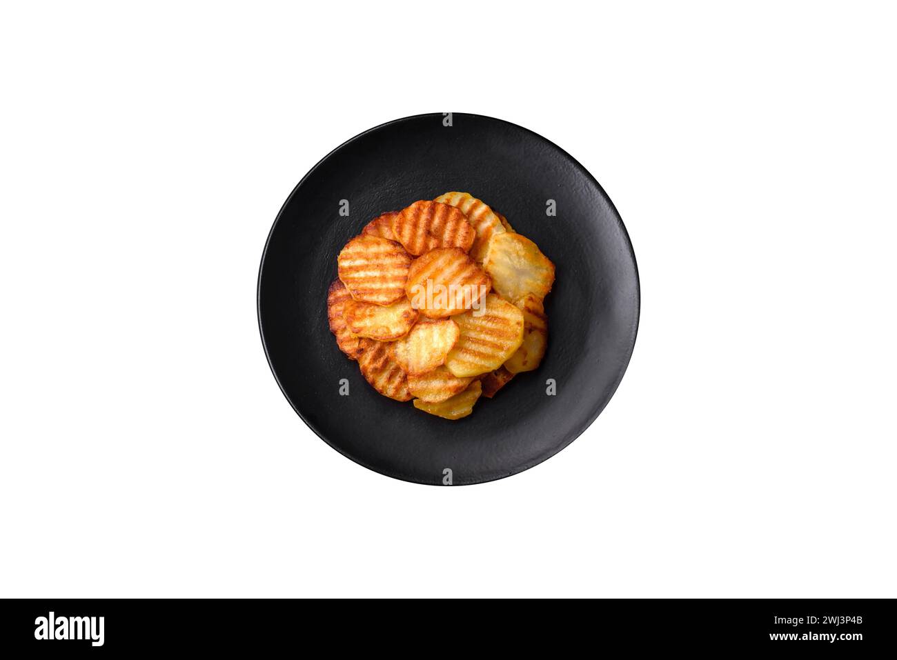 Köstliche knusprige Bratkartoffeln in Scheiben auf einer schwarzen Keramikplatte Stockfoto