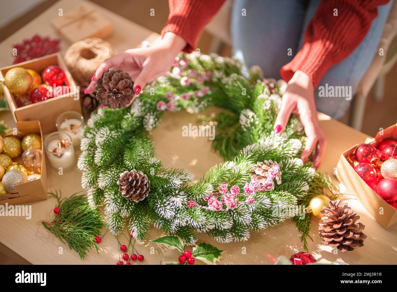 Frau, die Mistelkranz macht Weihnachtskranz Dekoration mit handgemachten DIY Winter Grün Blumenhändler Hände machen Weihnachtswrea Stockfoto