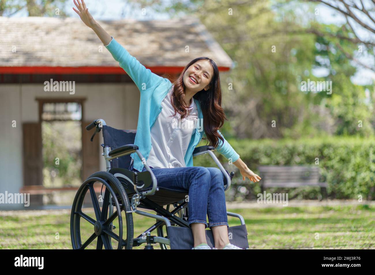 Junge asiatische Frau im Rollstuhl mit positivem Denken. Stockfoto