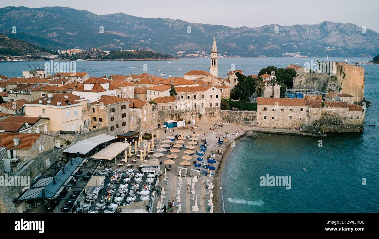 Strand in der Nähe der steinernen Festungsmauern der Altstadt von Budva am Meer. Montenegro. Drohne Stockfoto