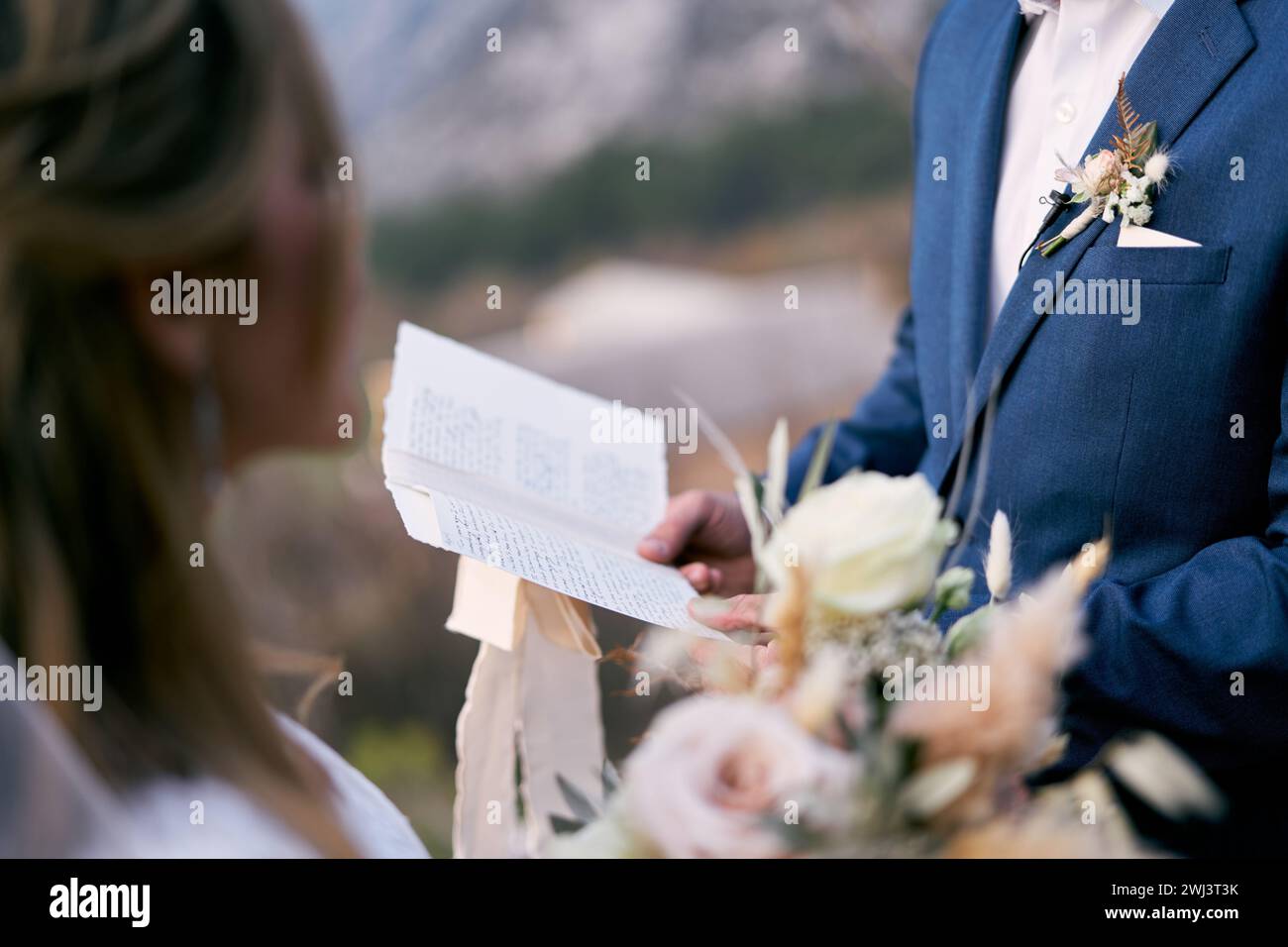 Der Bräutigam liest den Eid der Braut aus einem Blatt Papier vor Stockfoto