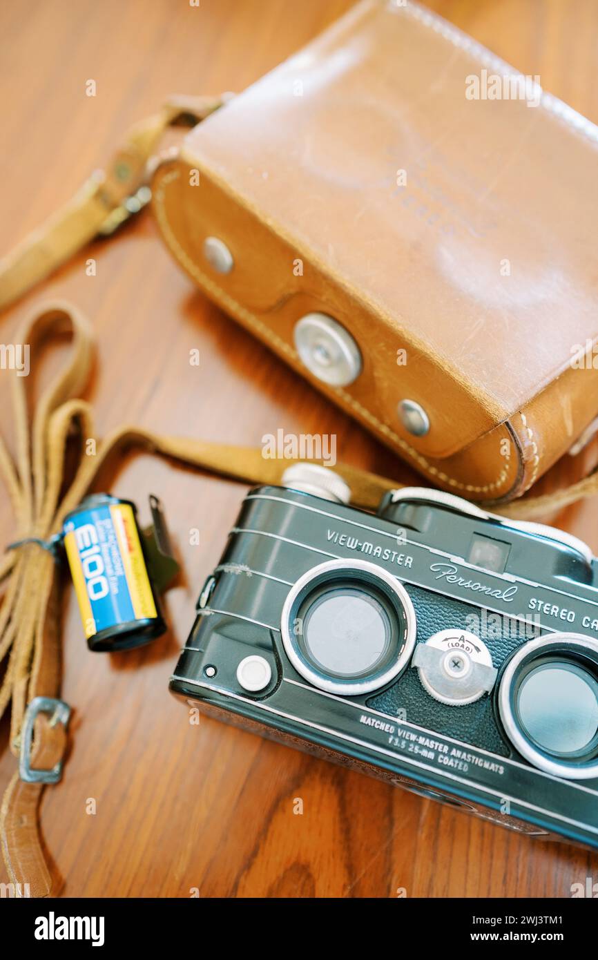 Die persönliche Stereokamera Vintage View Master liegt auf dem Tisch neben einem Lederetui Stockfoto