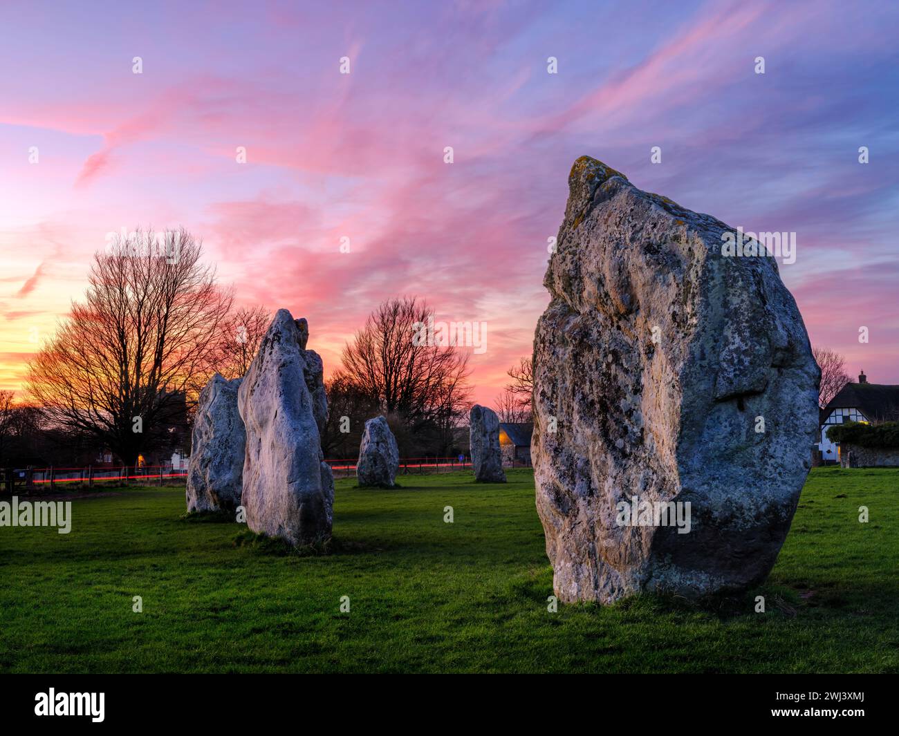 Montag, 12. Februar 2024 - Ein wunderschöner Himmel am Ende des Tages über dem alten megalithischen Steinkreis in Avebury, Wiltshire. Stockfoto