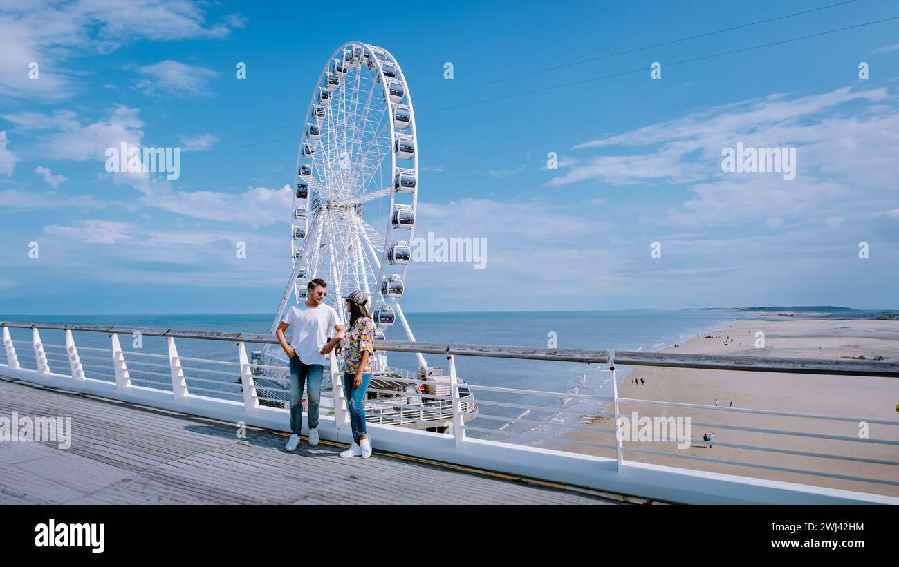 Paare besuchen das Riesenrad The Pier in Scheveningen, Den Haag, Niederlande Stockfoto