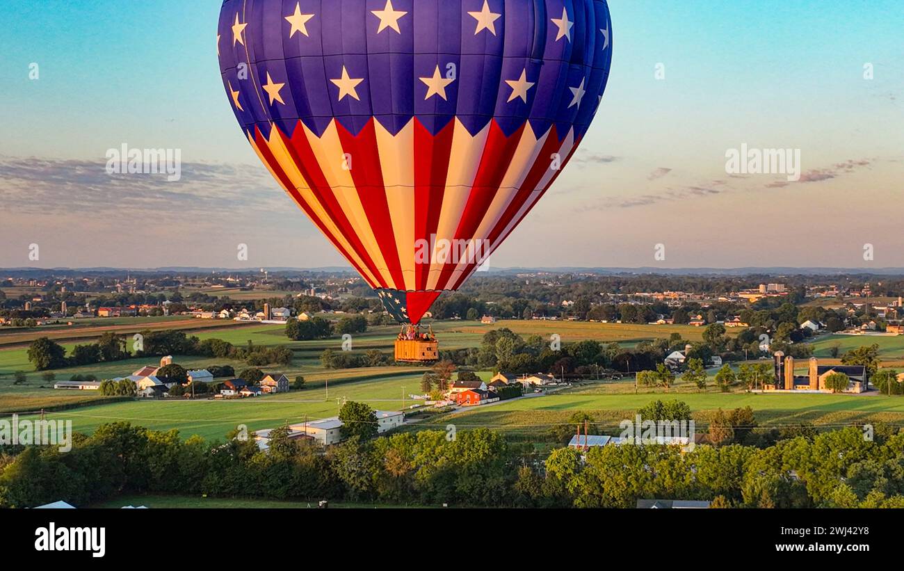 Ein Heißluftballon aus der Vogelperspektive, der bei Sonnenaufgang an einem sonnigen Morgen im ländlichen Pennsylvania abschwimmt Stockfoto