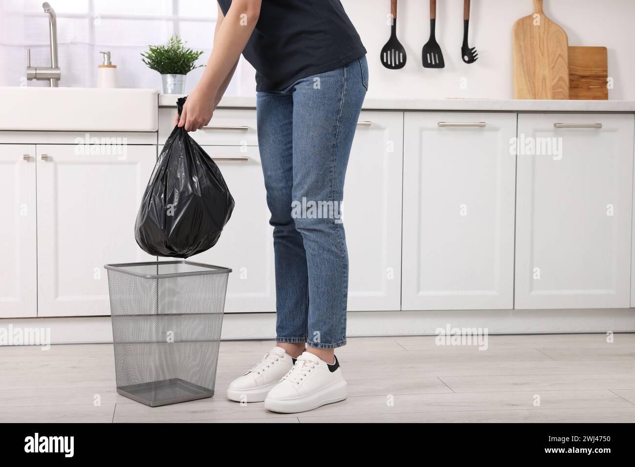 Frau, die Müllsack aus dem Mülleimer in der Küche nimmt, Nahaufnahme Stockfoto