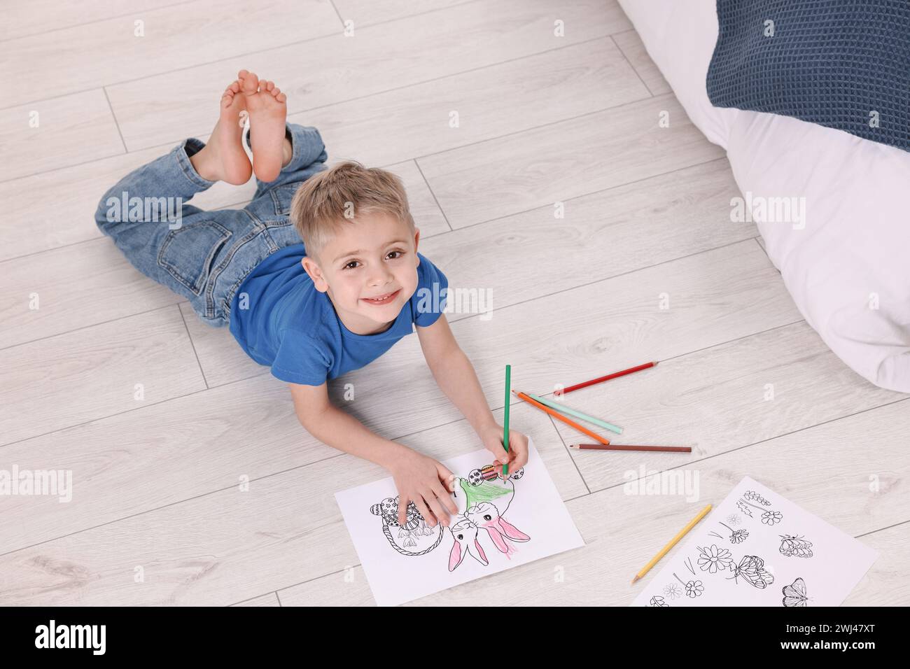 Niedliche kleine Jungen Färbung auf warmen Boden zu Hause. Heizung Stockfoto