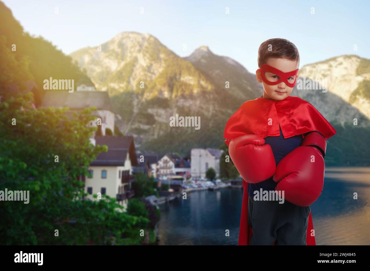 Superheld, Motivation und Kraft. Junge im cape und Maske mit Boxhandschuhen in den Bergen Stockfoto