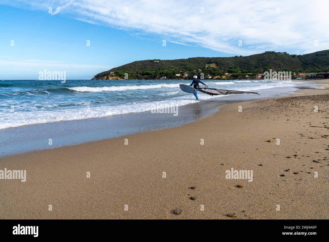 Mann, der sich auf das Windsurfen am Procchio Beach auf Elba Island vorbereitet Stockfoto