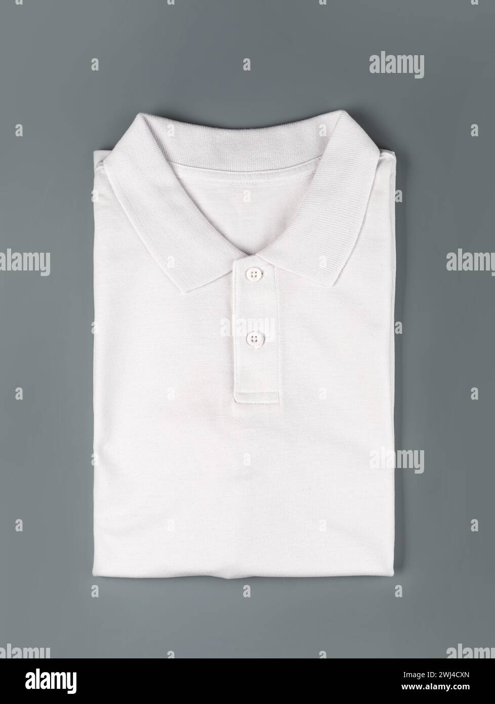 Weißes Poloshirt auf grauem Hintergrund. Stockfoto