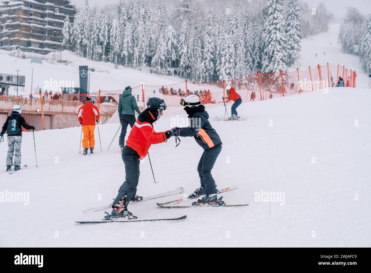 Skifahrer stehen am Berg und halten Hände in der Nähe der Skifahrer Stockfoto