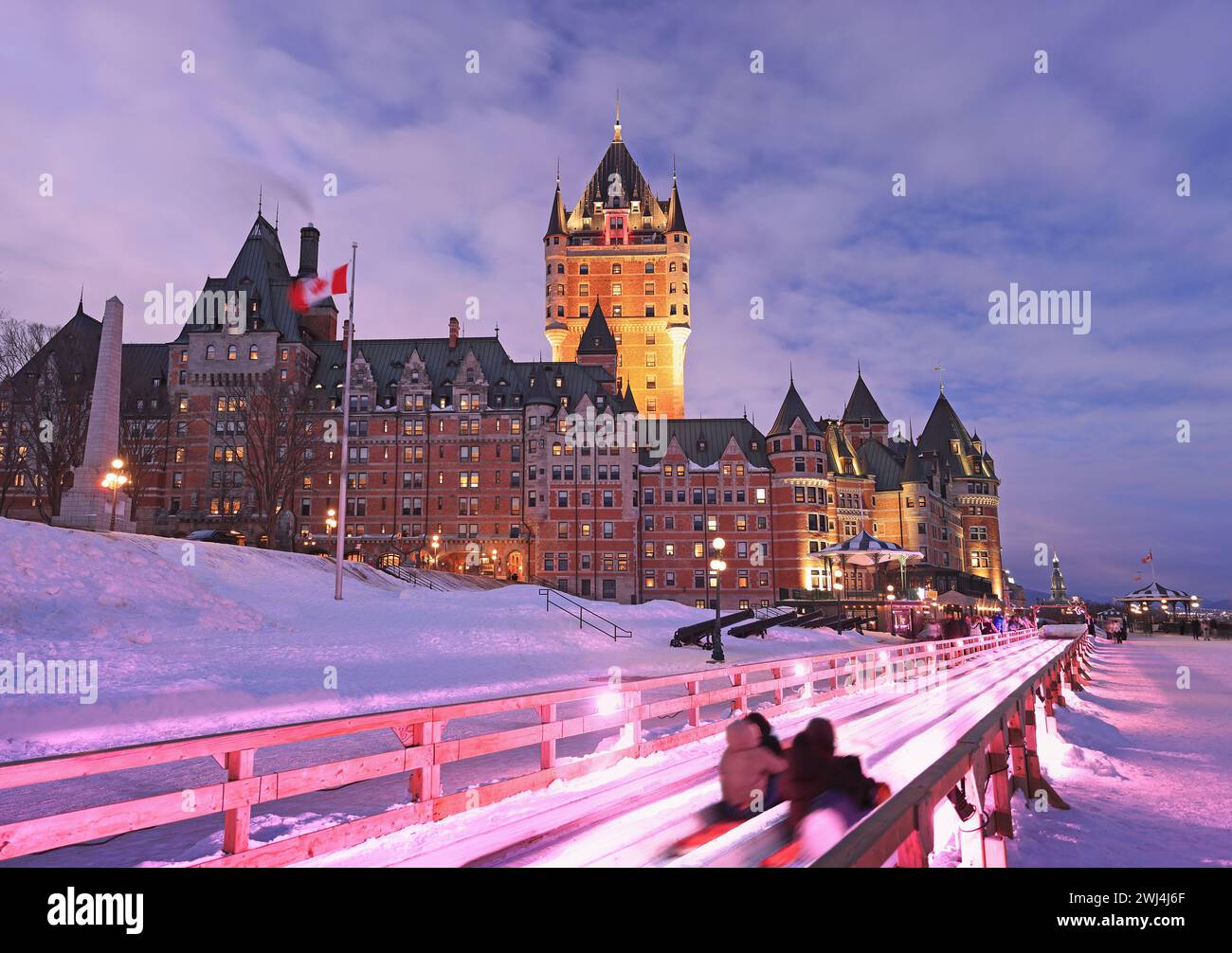 Traditionelle Rutschabfahrt im Winter in Québec City mit Frontenac Castle in der Abenddämmerung Stockfoto