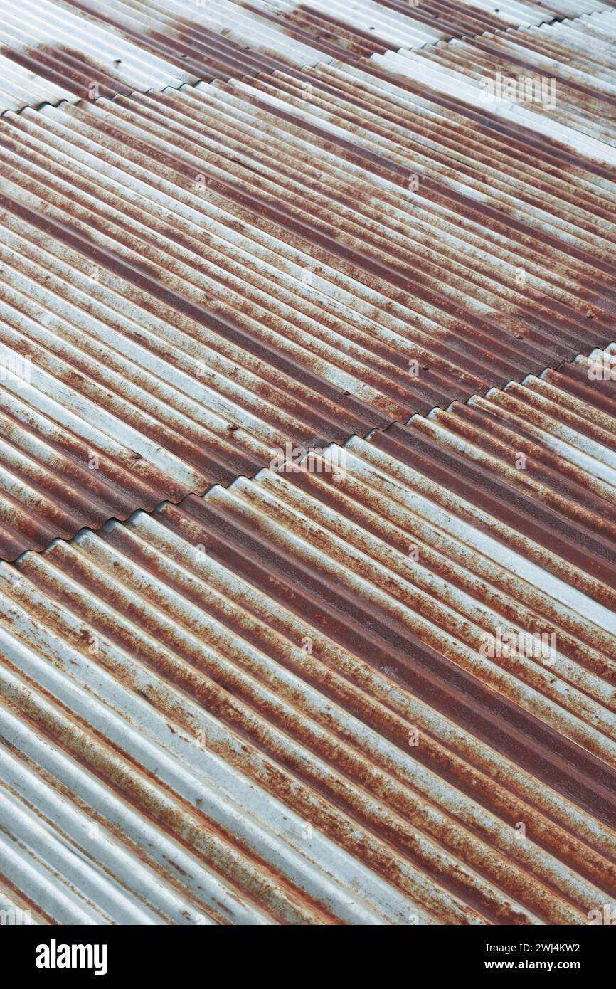 Abstrakt des alten Metallblechdachs, rostiges galvanisiertes Wellpappe weit verbreitet für seine Haltbarkeit und sein unverwechselbares Aussehen, weicher Fokus Stockfoto