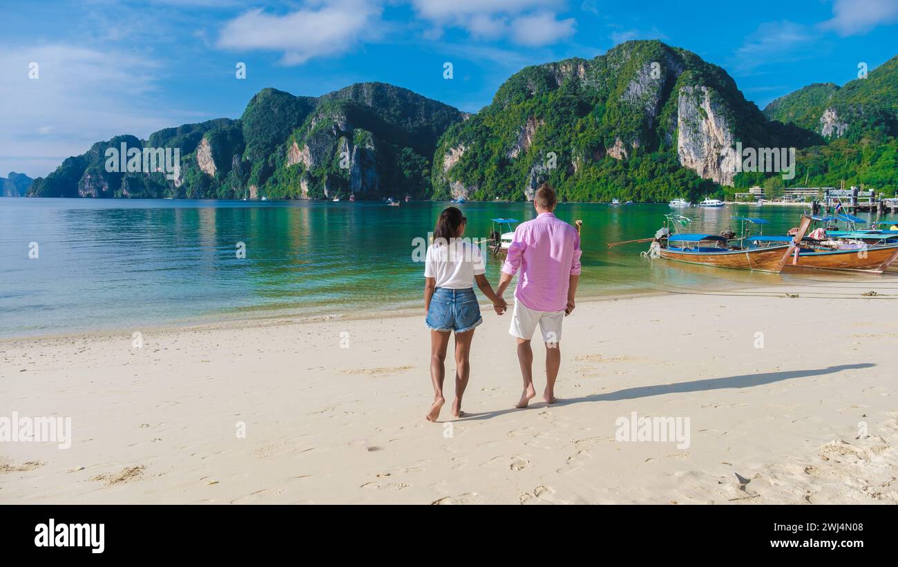 Ein paar Männer und Frauen im Kho Phi Phi Thailand gingen morgens am Strand entlang Stockfoto