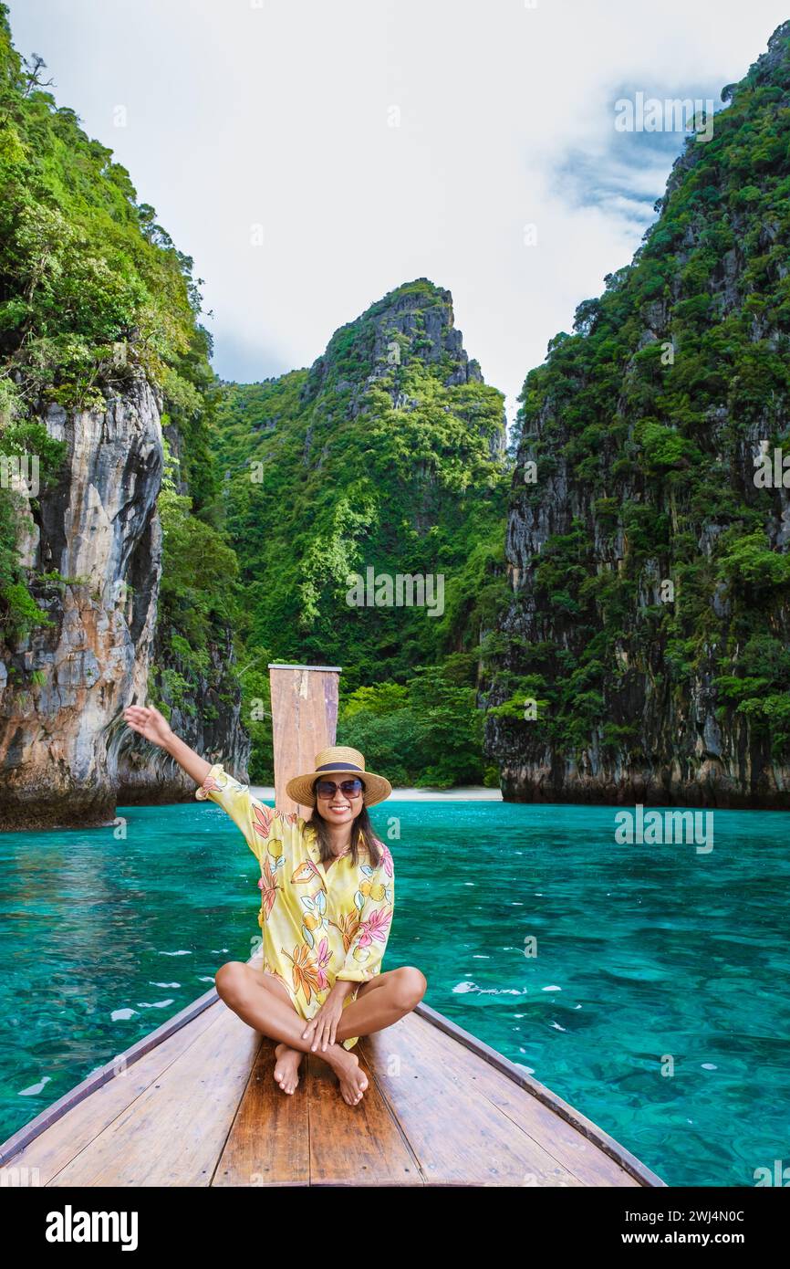 Asiatische Frauen vor einem Langboot in Kho Phi Phi Thailand Stockfoto