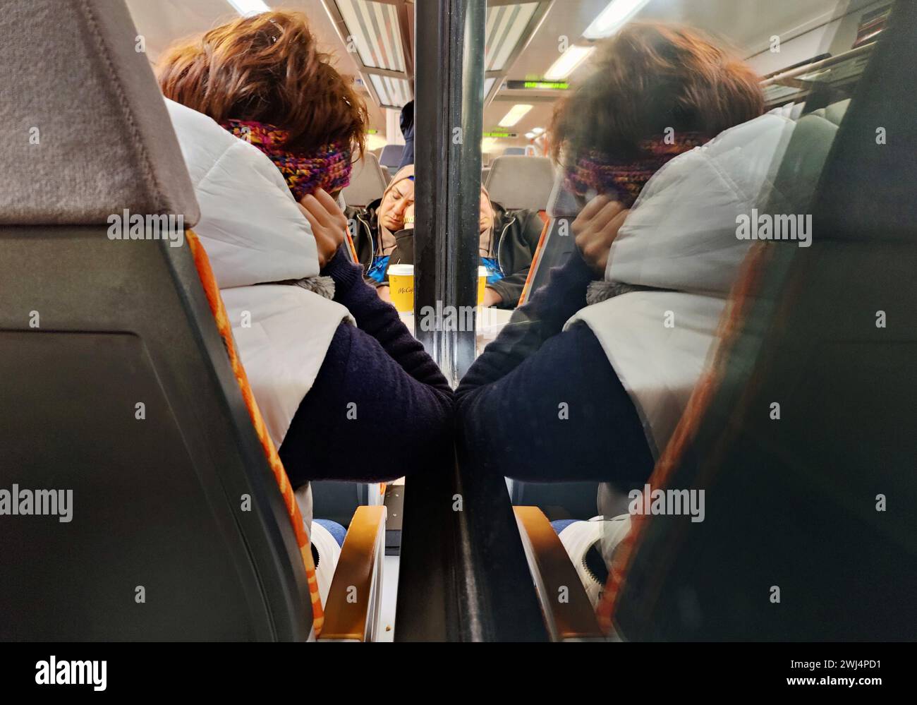 Blick auf schlafende Menschen in einem Nahverkehr durch die Nacht, Deutschland, Europa â€‹ Stockfoto