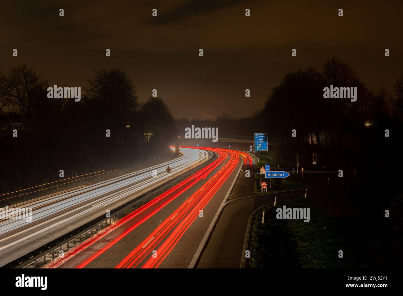 Lange Belichtung, weiße Vorder- und rote Rückleuchten, während die Autobeleuchtung nachts abstreift Stockfoto