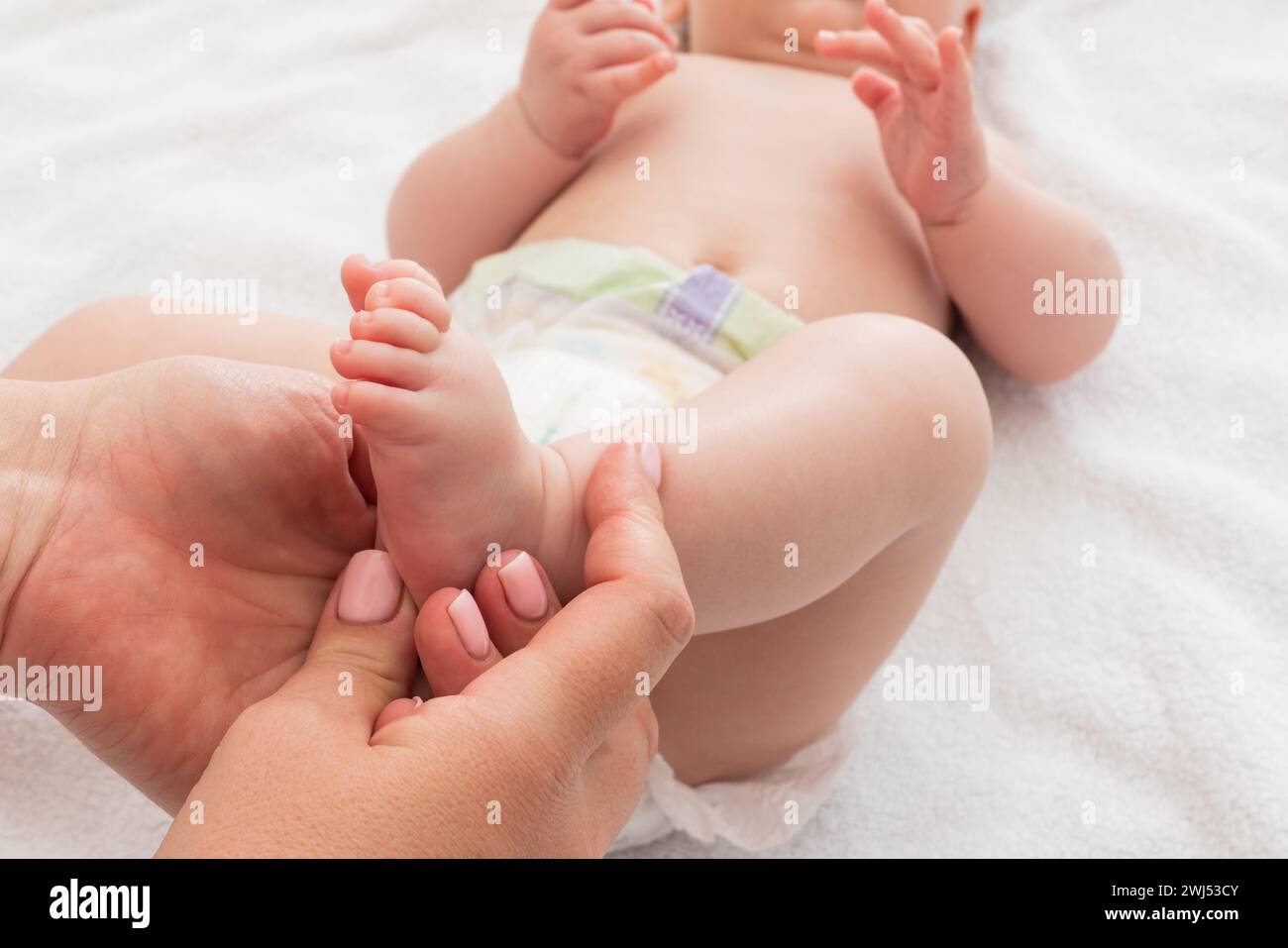 Das Neugeborene fühlt die wohltuende Note der Mutter, das Konzept von Massagenutzen und Entspannung Stockfoto