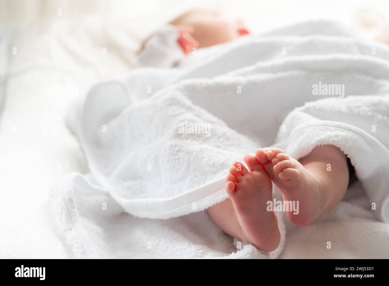 Die zarten Momente des Neugeborenen in weiß gehüllt. Konzept von Komfort und Wärme nach dem Bad Stockfoto