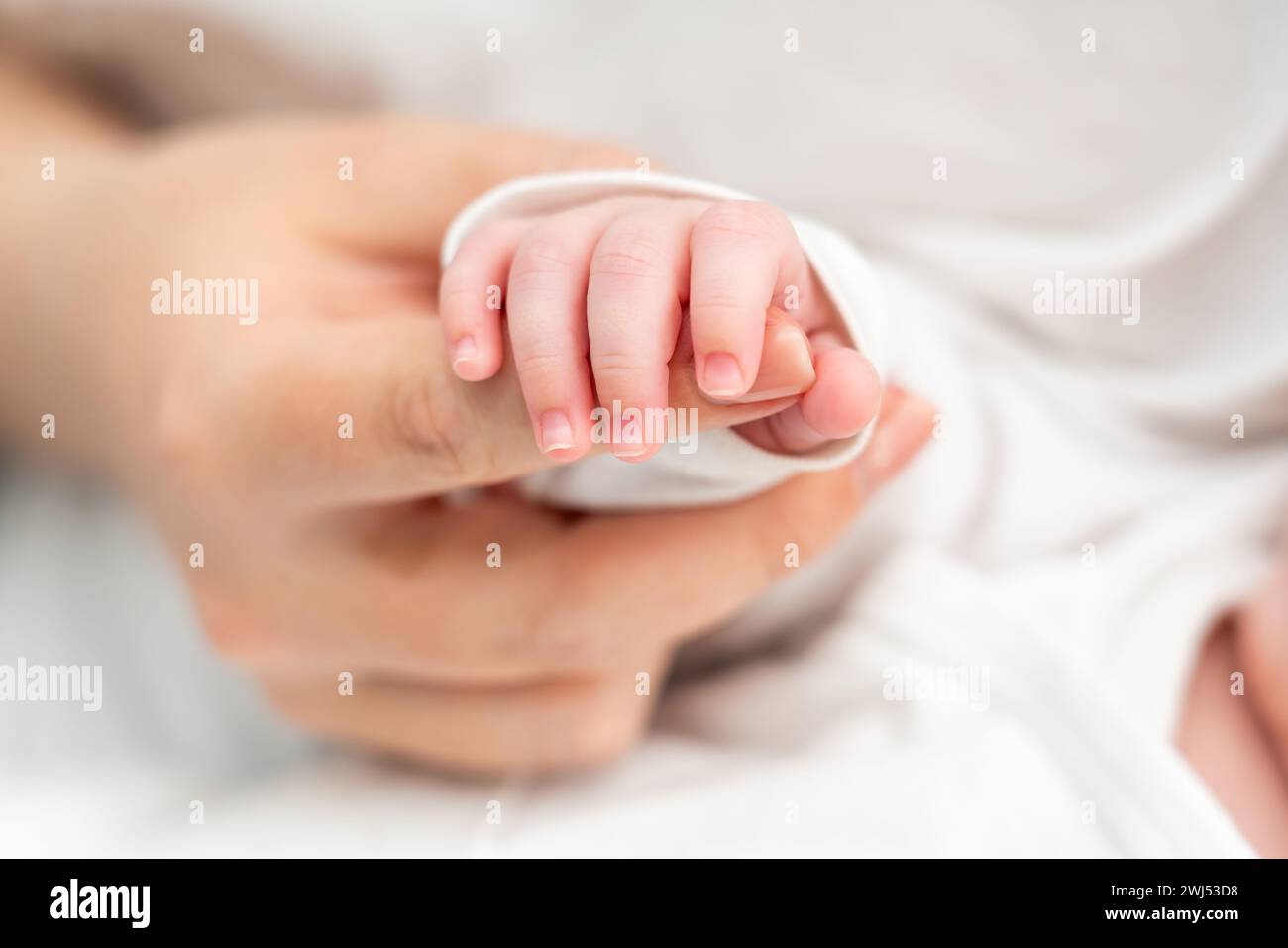 Das sanfte Greifen des Neugeborenen am Finger der Mutter ruft Emotionen hervor. Konzept mütterlicher Verbundenheit und Vertrauen Stockfoto