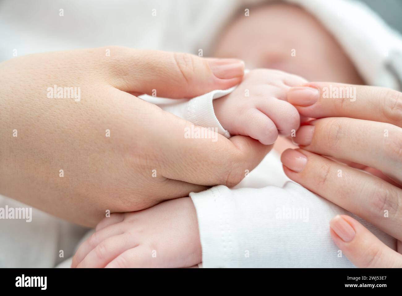 Die beruhigende Berührung der Mutter beruhigt ein krankes Neugeborenes. Das Konzept der Heilkraft der mütterlichen Bindung Stockfoto