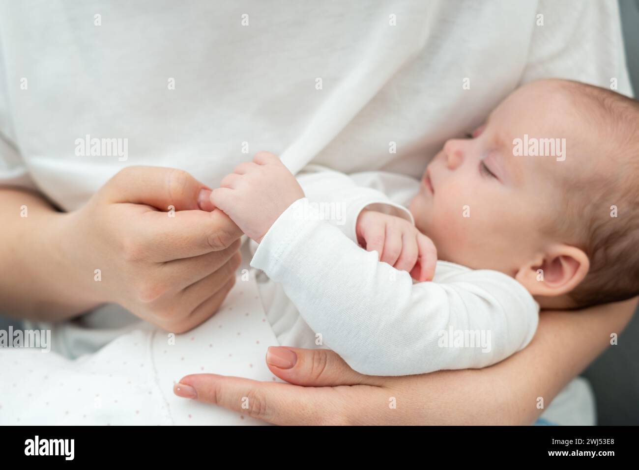 Die weiche Berührung des Säuglings, die den Finger der Mutter umklammert, spricht Bände. Das Konzept der reinen Mutter-Kind-Verbindung Stockfoto