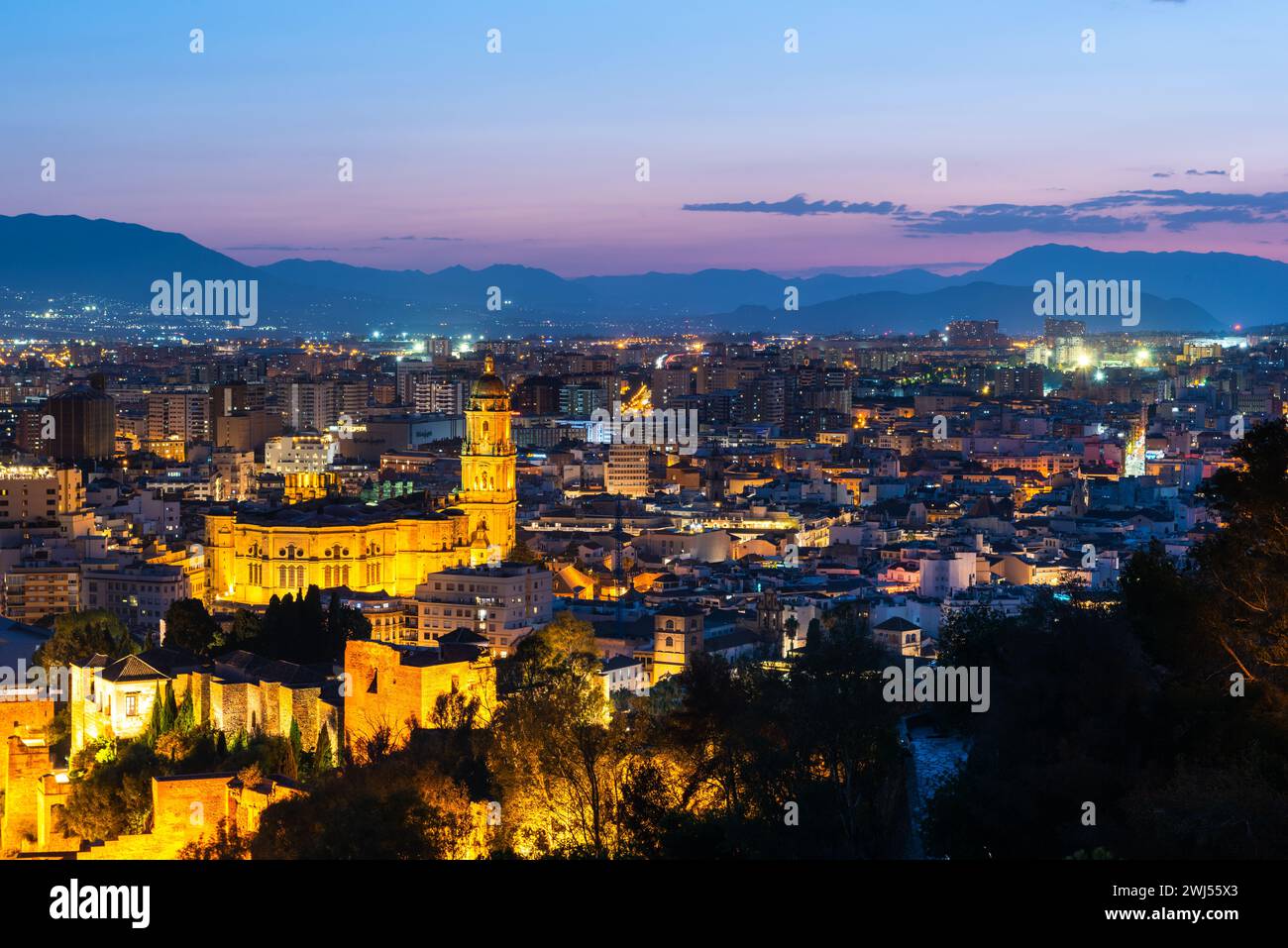 Skyline von Malaga, spanische Stadtlandschaft mit Kathedrale, Rathaus und Alcazaba Zitadelle von Malaga in der Abenddämmerung Stockfoto