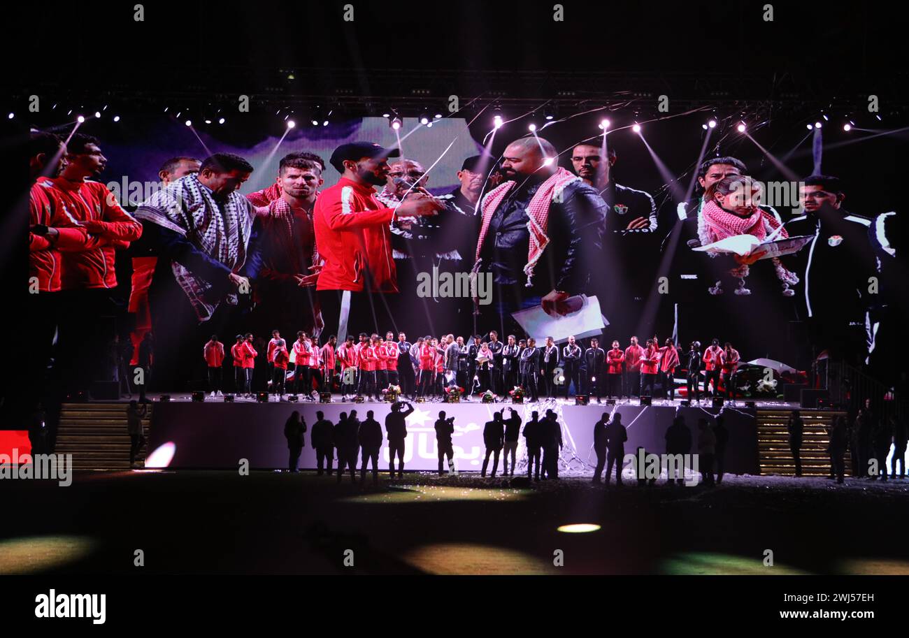 Amman, Jordanien. Februar 2024. Mitglieder der jordanischen Fußballmannschaft stehen während einer vom Jordan Football Association organisierten Begrüßungszeremonie im Amman International Stadium am 12. Februar 2024 auf der Bühne. Die jordanische Fußballmannschaft der Männer wurde in der jordanischen Hauptstadt Amman herzlich willkommen geheißen, nachdem sie beim AFC Asiencup in Katar den zweiten Platz erreicht hatte, nachdem sie das Finale gegen die Gastgebernation Katar verloren hatte. Quelle: Mohammad Abu Ghosh/Xinhua/Alamy Live News Stockfoto