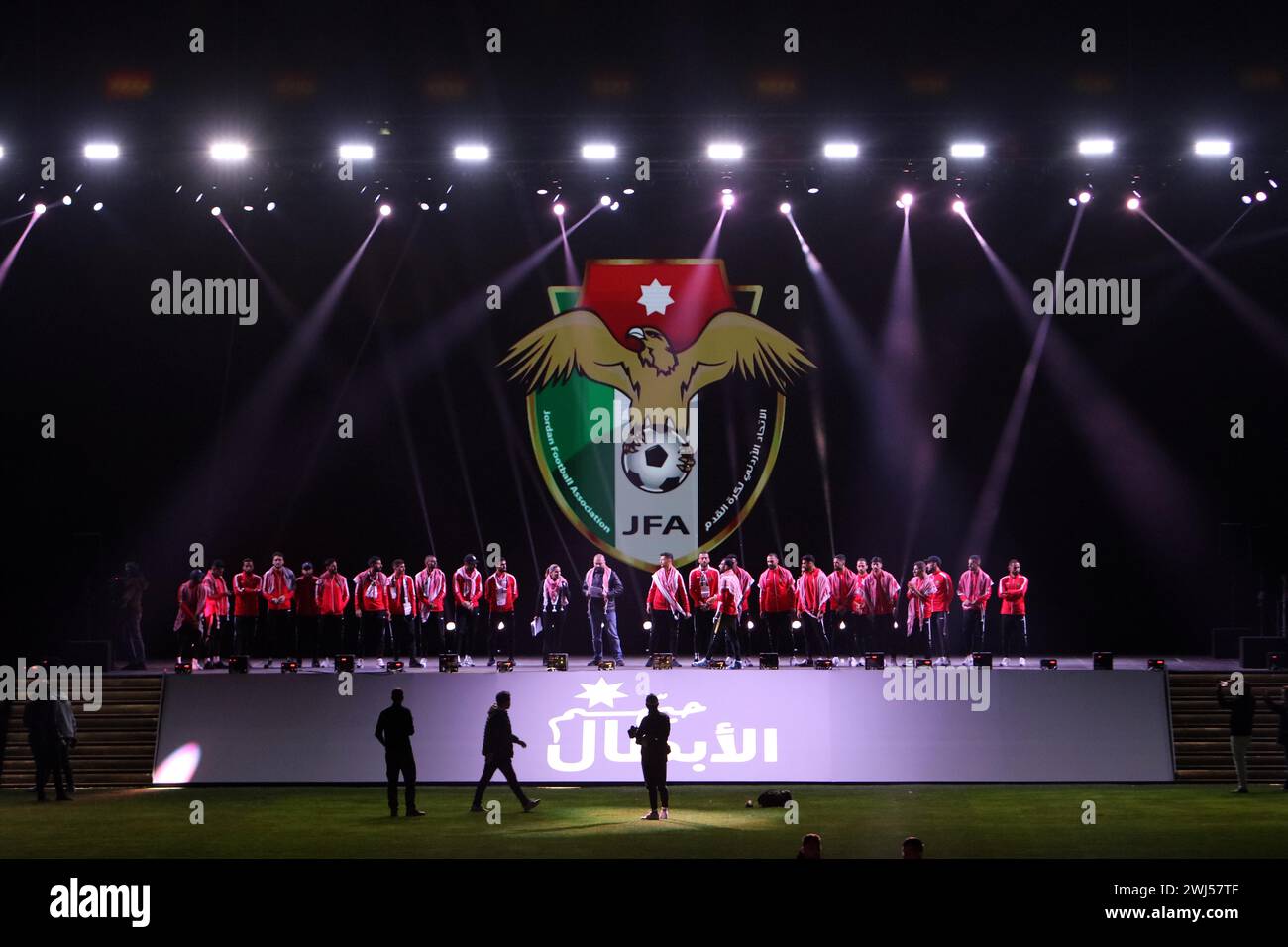 Amman, Jordanien. Februar 2024. Mitglieder der jordanischen Fußballmannschaft stehen während einer vom Jordan Football Association organisierten Begrüßungszeremonie im Amman International Stadium am 12. Februar 2024 auf der Bühne. Die jordanische Fußballmannschaft der Männer wurde in der jordanischen Hauptstadt Amman herzlich willkommen geheißen, nachdem sie beim AFC Asiencup in Katar den zweiten Platz erreicht hatte, nachdem sie das Finale gegen die Gastgebernation Katar verloren hatte. Quelle: Mohammad Abu Ghosh/Xinhua/Alamy Live News Stockfoto