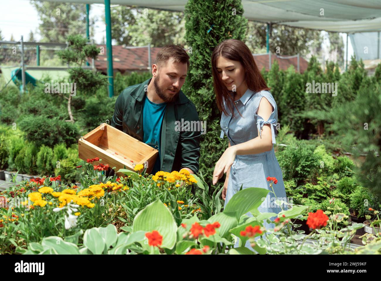 Mitarbeiter hilft weiblichen Kunden bei der Arbeit im Gartencenter Stockfoto