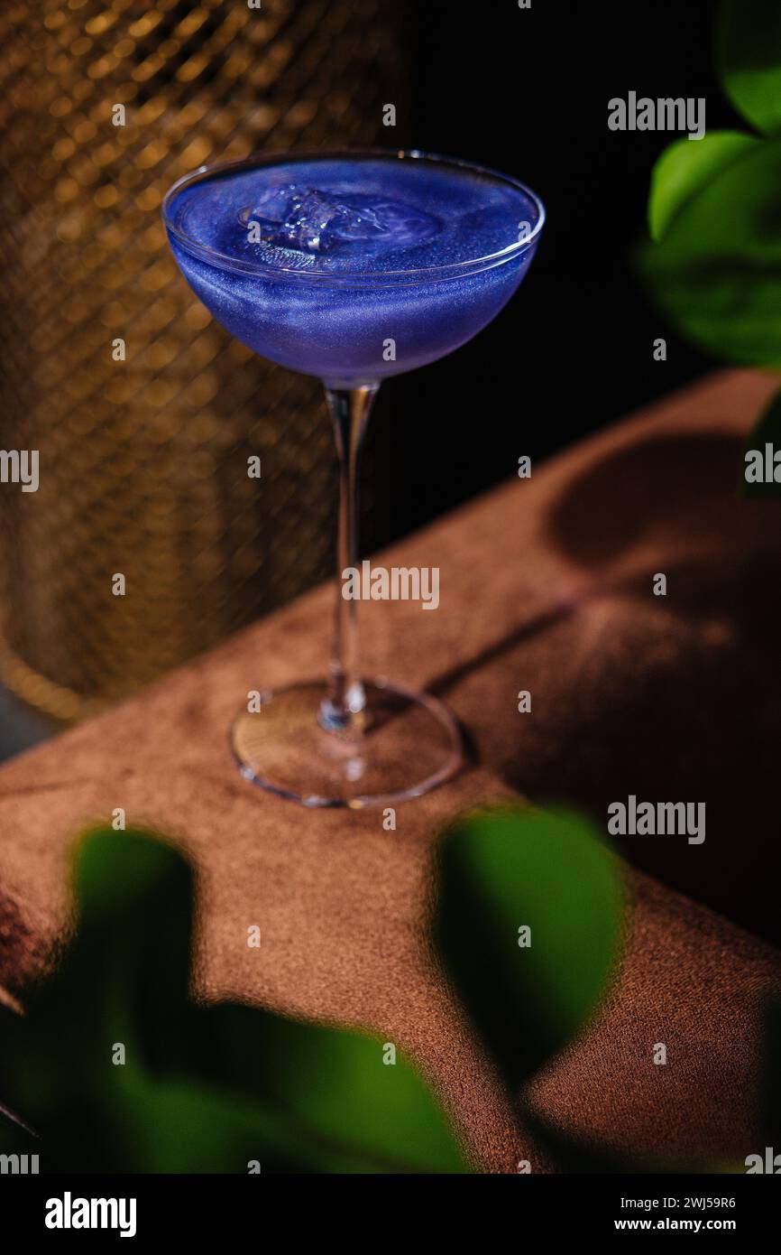 Cocktail basierend auf kohlensäurehaltigem Getränk in einem schönen Glas auf einem dünnen langen Bein Stockfoto