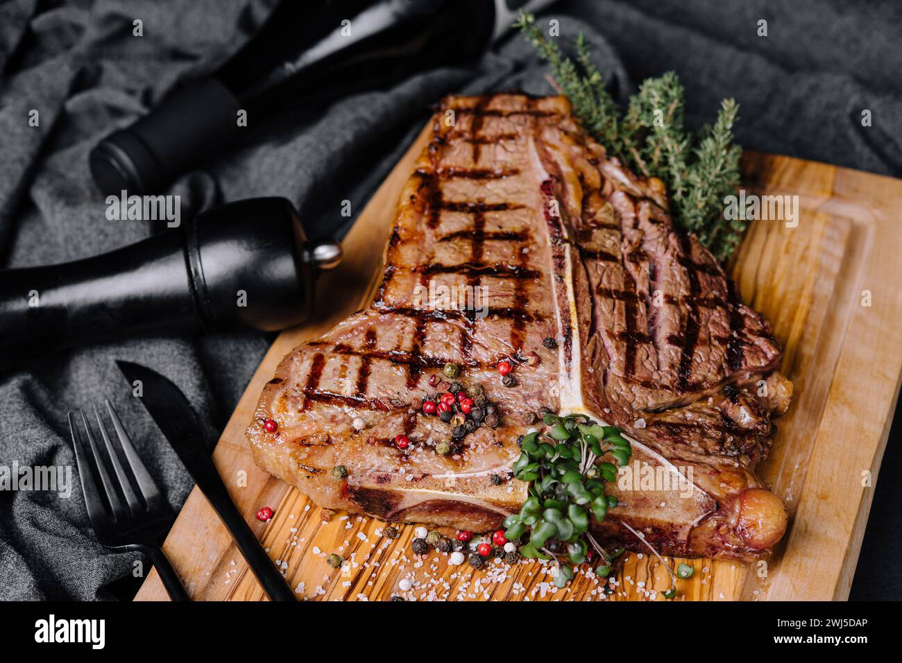 Ein großes gegrilltes Steak auf einem Holzteller Stockfoto