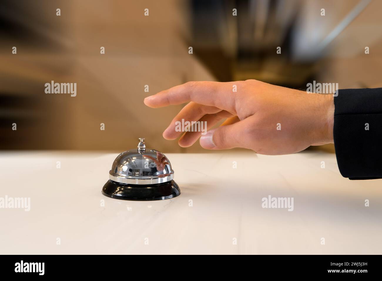 Die Hand eines Mannes wird eine alte Hotelglocke mit Bewegungsunschärfe-Effekt verwenden Stockfoto
